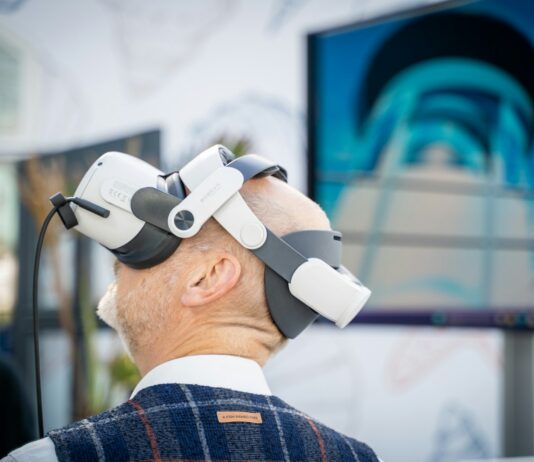 운동의 패러다임이 바뀐다 – ‘양’보다 ‘질’, ‘강도’보다 ‘타이밍’ A man wearing a robot headpiece in front of a TV