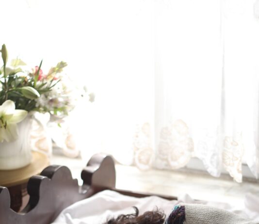 “슬기로운 수면 습관, 한국인의 건강 지키는 첫걸음” woman sleeping on bed beside book