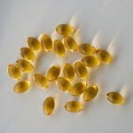 “내 몸을 위한 영양 관리, 보충제 올바르게 활용하는 법” a pile of fish oil capsules sitting on top of a table