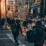 ‘마이크로 걷기’ 확산…분할 운동으로 건강 챙기는 실천법 주목 a group of people walking down a street next to tall buildings
