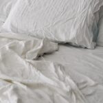 달라진 ‘수면 건강’ 트렌드… 내 몸에 맞는 수면 루틴 찾기가 중요 A rumpled white duvet and pillows on a bed.